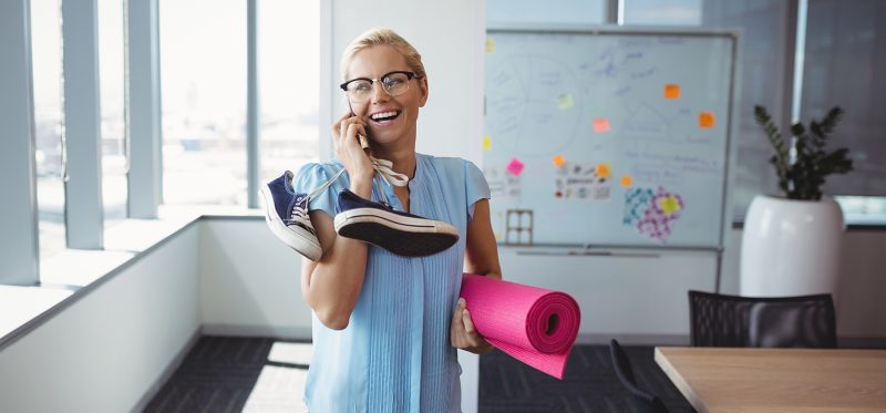 Young business woman with yoga mat